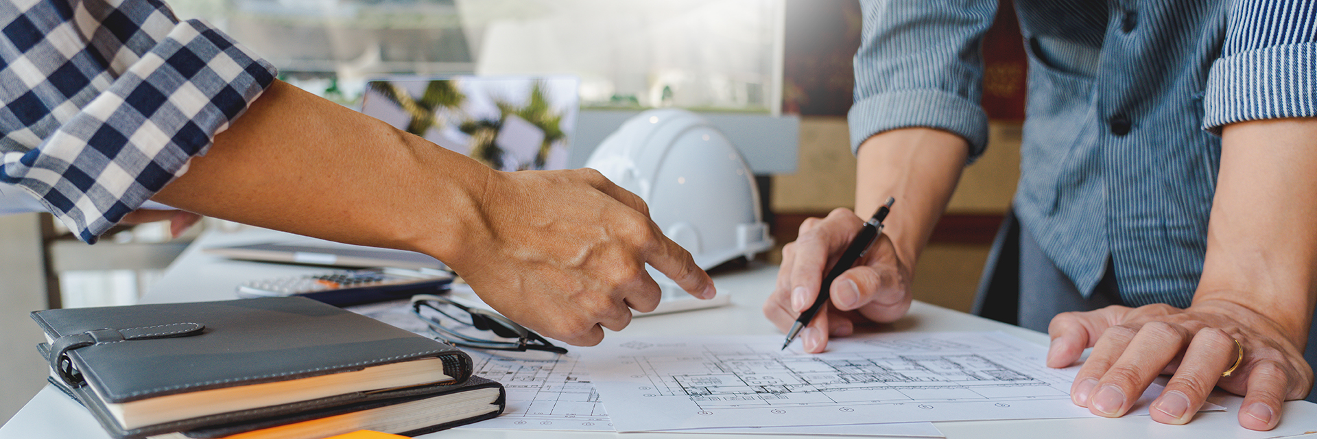 Employee hands pointing at blueprints