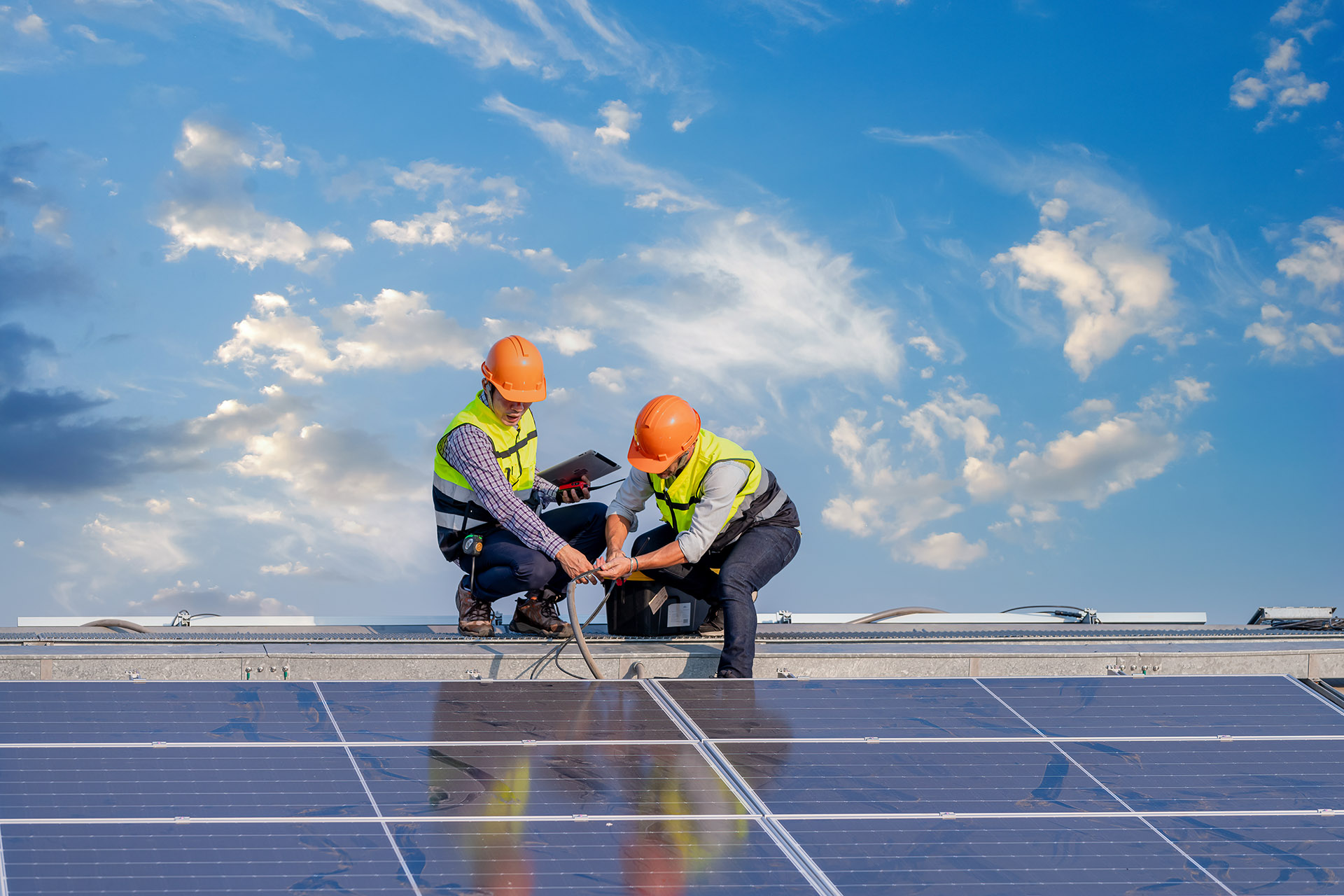 Two engineers looking at solar panels on a roof
